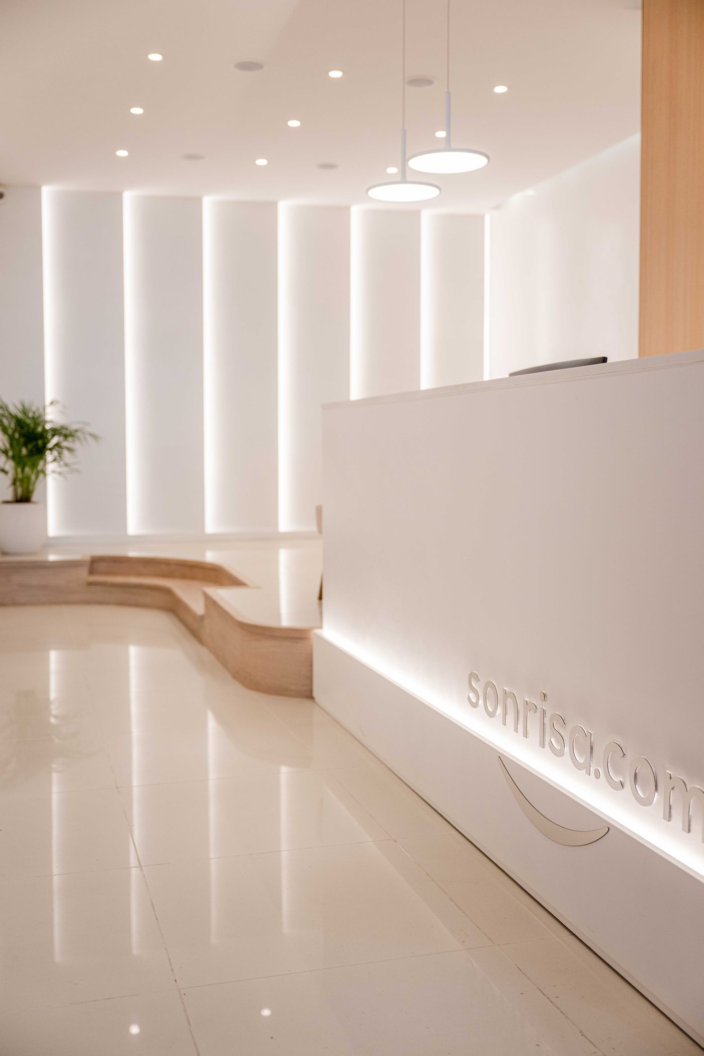 Recepción de la clínica Sonrisa, con el logo en el mostrador